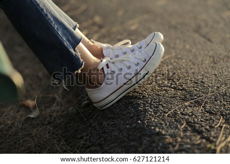 leg woman sneaker jeans with sunset light Royalty-Free Stock Photo #627121214