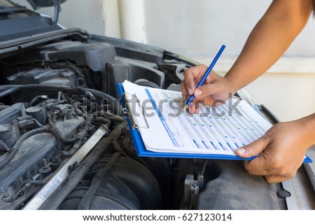 Auto mechanic (or technician) checking car engine at the garage, industrial concept Royalty-Free Stock Photo #627123014