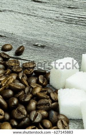 coffee grains and sugar on grunge wooden background