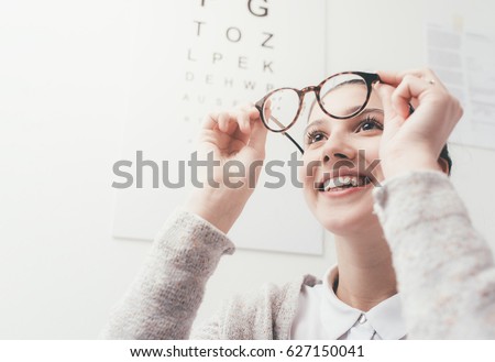 Happy young woman trying her new glasses, eye care concept Royalty-Free Stock Photo #627150041
