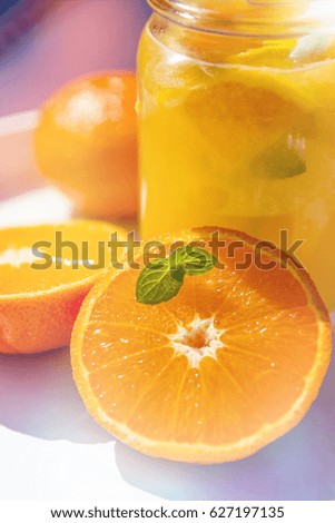 Fresh squeezed orange juice in a jar on blue woodwn table with leaf of mint.top view Copy space.Tropical Background Holiday Travel Bright Toned Design View