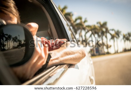 Photographer is riding in a car and trying to take a photo through an open window