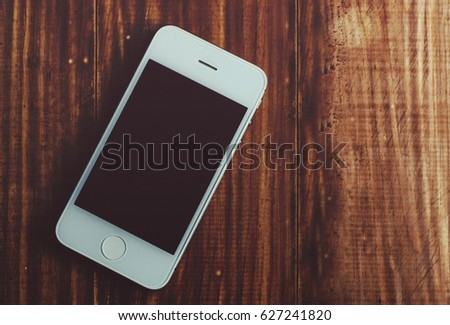 Phone mock-up on the wooden rustic office table