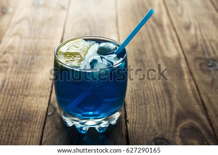 light blue alcoholic drink curacao liqueur on wooden background Royalty-Free Stock Photo #627290165