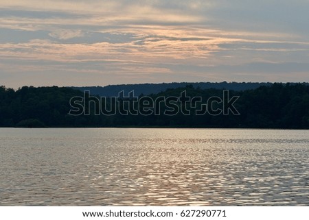 Beautiful landscape with the lake and the forest on the sunset