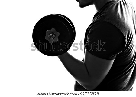 Back lit silhouette of a young man lifting weights in black and white.