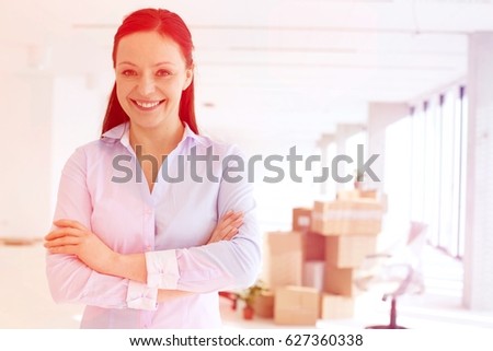 Portrait of smiling mid adult businesswoman standing arms crossed in new office