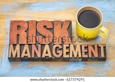 risk management banner in vintage letterpress wood type blocks with a cup of coffee