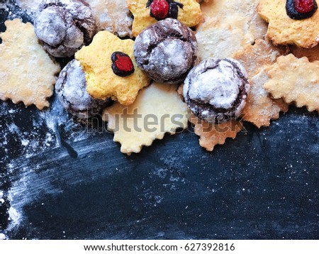 Festive cookies on a black kitchen board with powdered sugar. Restaurant photo with space for your text. View from above