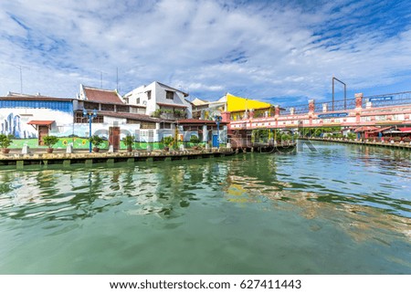 Empty river with small pedestrian bridge during a sunny cloud blue sky in Melaka, a UNESCO World Heritage Site since 7 July 2008. Rustic walkway along the historical river town of Malacca, Malaysia.