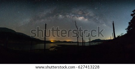 Panorama landscape with Milky Way. Night sky with stars and dead trees at chanthaburi Thailand