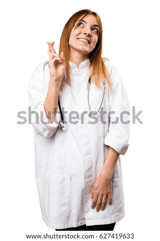 Young doctor woman with her fingers crossing