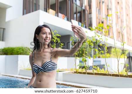 Woman taking selfie by mobile phone in jacuzzi spa