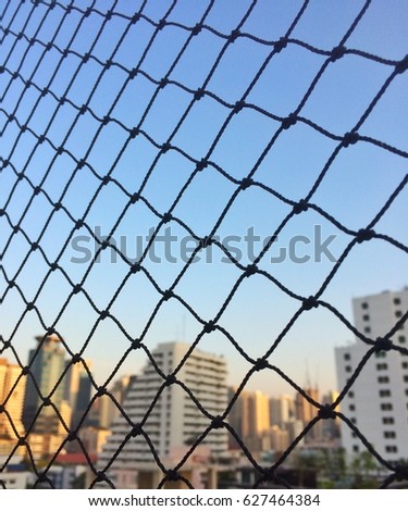 Rope fence with rooftop sunset view in city