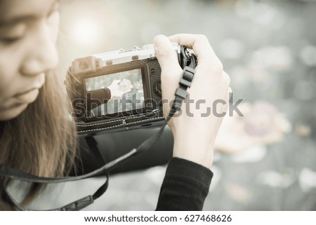 Close up  of a traveling woman is taking pictures on cosmos  flower background.