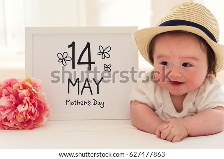 Mother's Day massage with happy baby boy with a pink flower