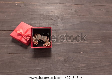 Red gift box on the wooden background with empty space.
