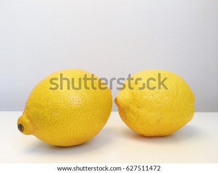 two fresh lemon fruit on top of white table