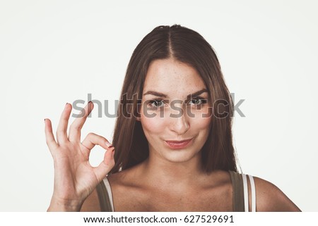 Happy young woman showing ok sign with fingers