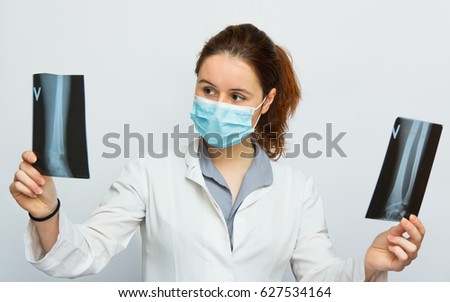 Young female doctor looking at the x-ray picture no white background