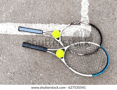 Tennis. Two tennis racquets and two tennis balls.