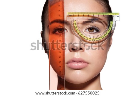 Close-up of a woman's face measure rulers before a plastic surgery to change the proportions. Isolated on white background