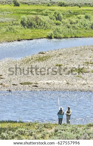 Couple fly fishing in the Lamar river, Yellowstone National Park.
