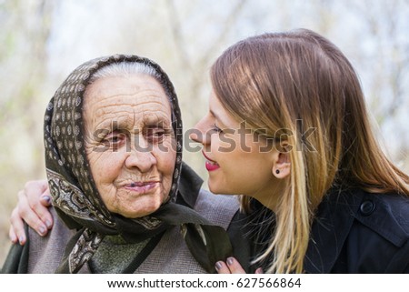 Picture of a beautiful young woman kissing her sick grandmother