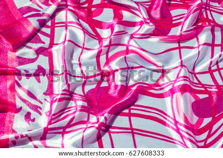 Texture, fabric, background. Texture of a female dress with an abstract red pattern on a white background. Silk fabric geometric shapes