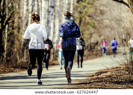 morning run group women running in sunny city park Royalty-Free Stock Photo #627626447