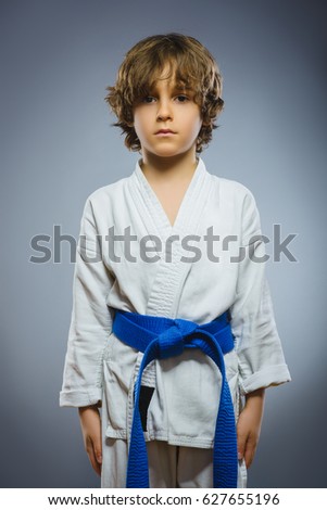 boy in kimono during training karate exercises isolated on gray background