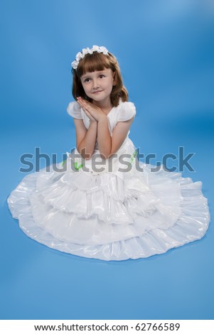 The girl the princess in a white dress. Blue background.