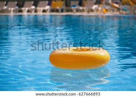 floating ring on blue water swimpool with waves reflecting in the summer sun Royalty-Free Stock Photo #627666893
