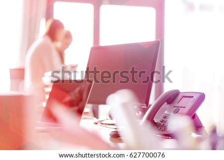Landline phone with laptop and computer on office desk