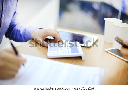 Businessman using a calculator to calculate numbers