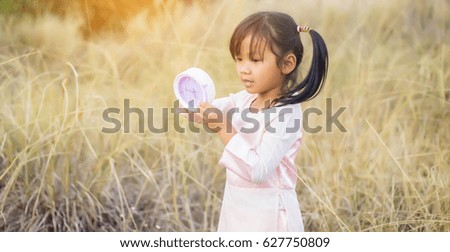Little nerdy girl in panic holding clock 