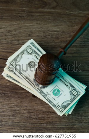 Judge's hammer lies on dollars