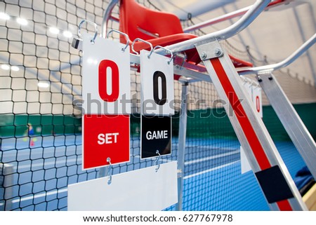 Umpire chair with scoreboard on a tennis court before the game.