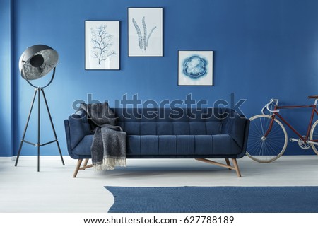 Red bicycle in modern designed blue living room with fancy lamp