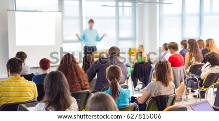 Business and entrepreneurship symposium. Speaker giving a talk at business meeting. Audience in conference hall. Rear view of unrecognized participant in audience. Royalty-Free Stock Photo #627815006