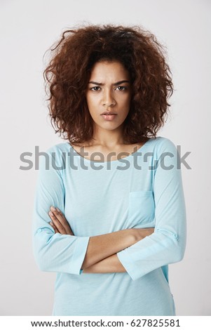 Displeased beautiful girl looking brutally at camera with crossed arms. Quarrelling with her boyfriend after long night. Portrait of young woman in pyjamas in morning.