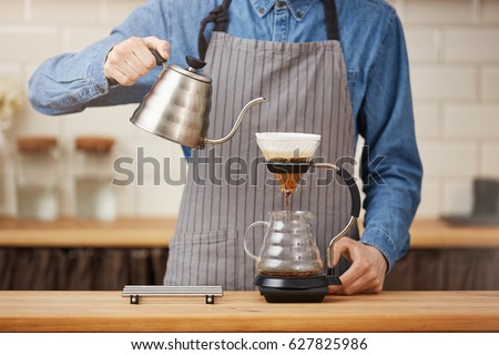 Coffee brewing gadgets. Male bartender brewing pourover coffee at bar. Royalty-Free Stock Photo #627825986
