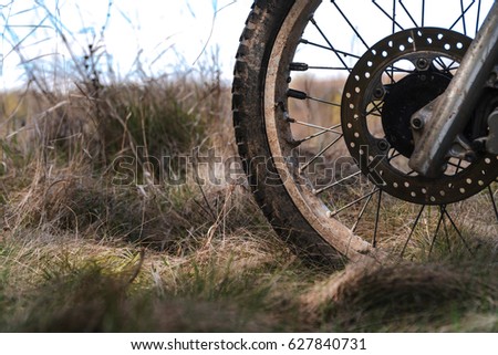 Close-up of muddy front wheel of dirt bike, details