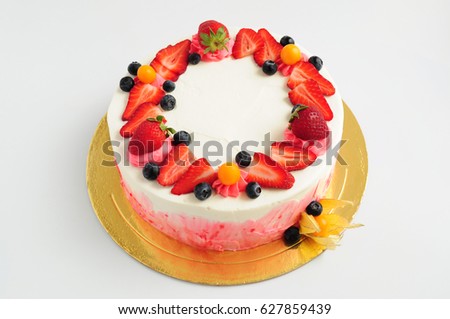 Cake with whipped cream fresh strawberries, blueberries and physalis. Picture for a menu or a confectionery catalog.