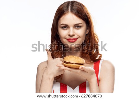 Woman with a hamburger on a light background