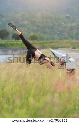 Young girl doing yoga fitness exercise Morning sunrise outdoor in  the meadow beautiful mountains landscape. Meditation and Relax.