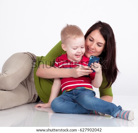 little handsome boy with mother playing with cell phone isolated on white