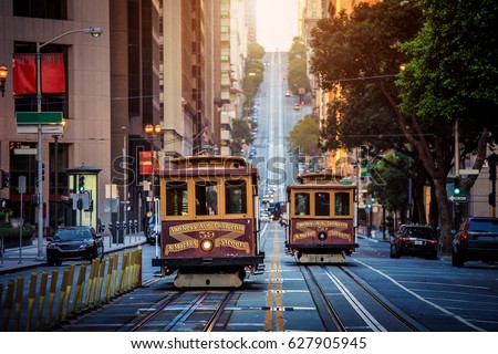 Classic view of historic traditional Cable Cars riding on famous California Street in morning light at sunrise with retro vintage style cross processing filter effect, San Francisco, California, USA Royalty-Free Stock Photo #627905945