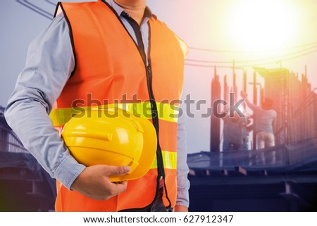 engineer holding protection equipment on site  background