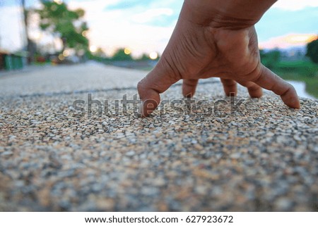 hand clinging on walkway stone in the public park select focus with shallow depth of field.